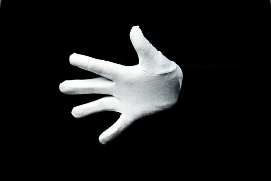 A Hand Wearing White Glove On Black Background Counting Down