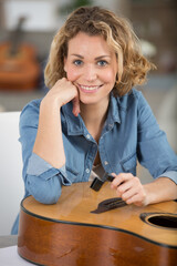 luthier apprentice cleans concert guitar with care