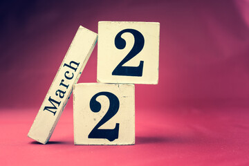 March 22nd, Twenty-second of March, Day 22 of month March - vintage wooden calendar blocks on maroon background with empty space for text