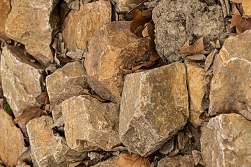cobblestone pattern rough and hard dark brown many stones with dry leaves mountainside