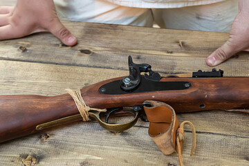 old muzzle-loading weapon, trigger traditional musket on a wooden table
