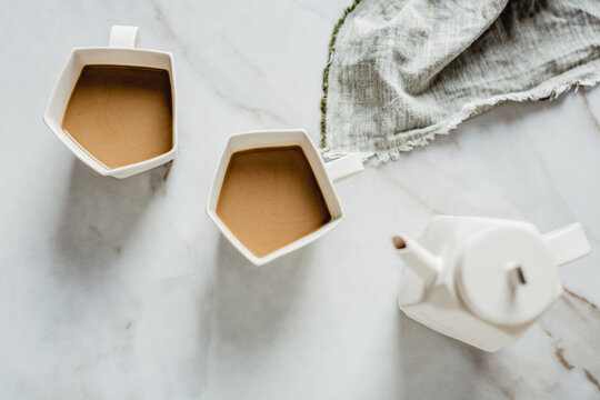 Artistic mugs with coffee and milk