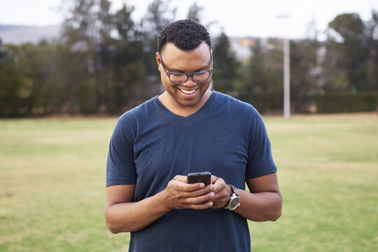 Happy black man using a cell phone in a park