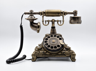 Vintage telephone in bronze color with white background