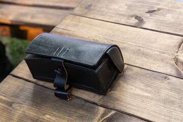 black and leather cartridge belt for vintage weapons lies on a wooden surface