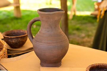 a jug made of clay is on the table a summer kitchen under the tent