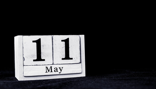 May 11th, Eleventh of May, Day 11 of month May - vintage wooden white calendar blocks on black background with empty space for text