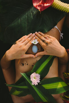 Beautiful naked female body covered with tropical flowers and plant