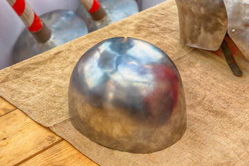 iron silver helmet round small protection medieval soldier lies on a wooden background