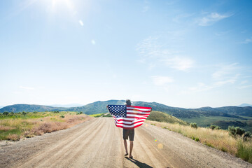Man Holding American Flag on Dirt Road