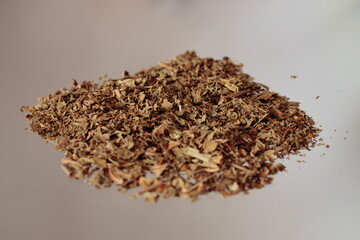 handful of dried basil leaves on a light background.