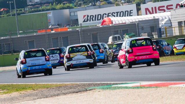 Mercedes Smart electric championship, group of cars rear view challenging for overtaking racing on circuit asphalt track