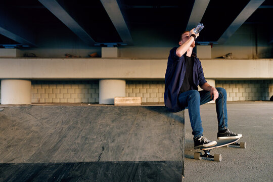 thirsty man on skate drinking water from the bottle