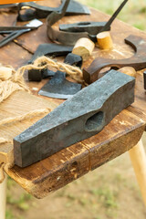 iron head of a hammer A large construction tool lies on a table against the background of an ax. selective focus