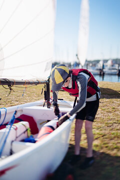 Boy checking his sail boat before a regatta