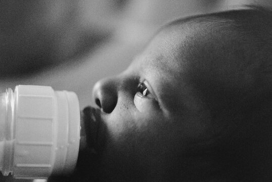 Bottle fed baby in early morning light