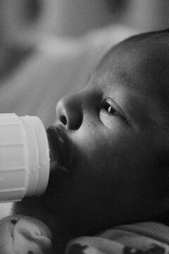 Baby boy bottle feeding in the morning light