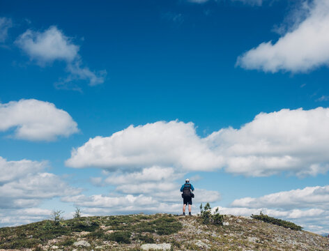 Male backpacker standing on mountain summit, taking in view