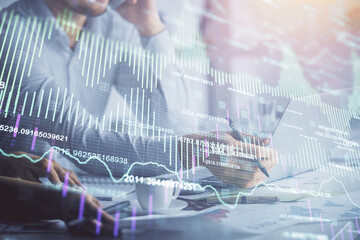 Double exposure of man and woman working together and financial graph hologram. Business concept. Computer background.