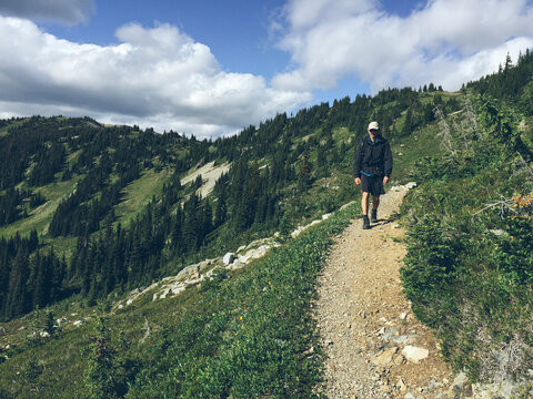 Man backpacking in mountains, North Cascades, WA