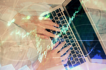 Double exposure of woman hands working on computer and forex chart hologram drawing. Top View. Financial analysis concept.