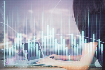 Double exposure of businesswoman hands typing on computer and forex chart hologram drawing. Financial analysis concept.