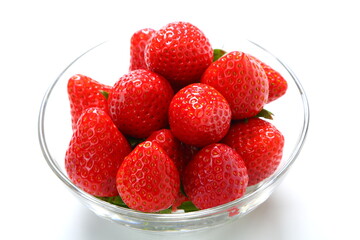 Ripe strawberries in glass bowl on white background 