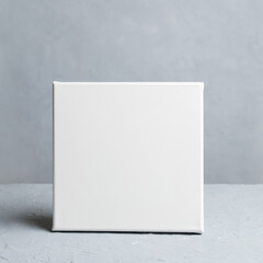 Blank square canvas in grey room. Mockup poster frame.