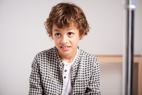 Curly-haired boy looking with skepticism