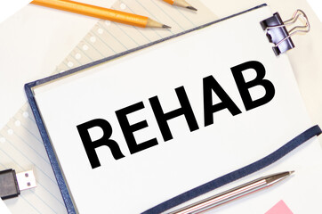 REHABILITATION word on the card shown by a man