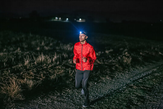 Man running on a field path at night.