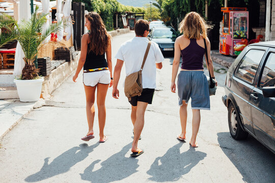 Group of friends walking on the street by the beach