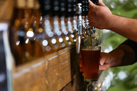 Barman pouring IPA into pint glass