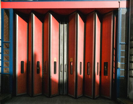 Facade of an old Fire Station with red doors.