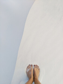 Lady's feet on the white sand