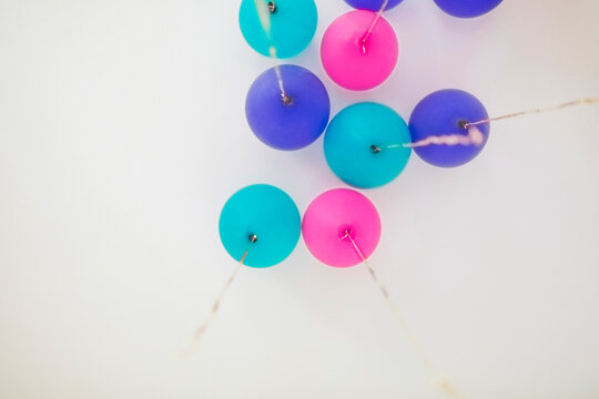 Many ballons in different colors with gold sequin strings seen from below
