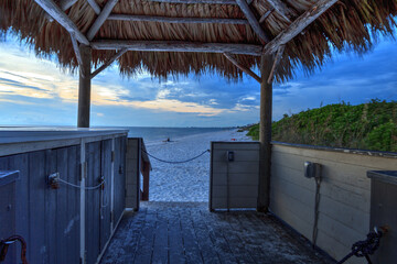 Tiki hut Boardwalk leads down to the white sand of Barefoot Beach in Bonita Springs
