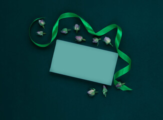 Still life of  ribbon, dry rosebuds and cards for the text.