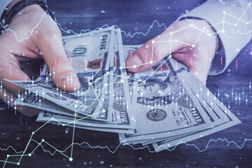 Multi exposure of financial graph drawing hologram and USA dollars bills and man hands. Analysis concept.