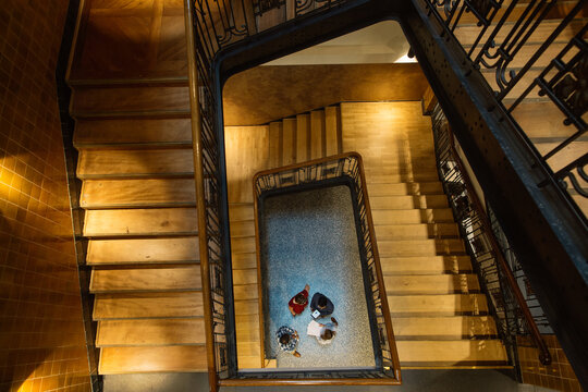 Overhead Shot of Four People Meeting Informally at Bottom of Staircase