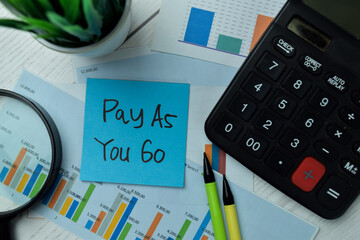 Pay As You Go write on sticky notes isolated on office desk.