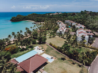 Aerial drone view of residence beach club with the pool at the paradise beach with palm trees and...