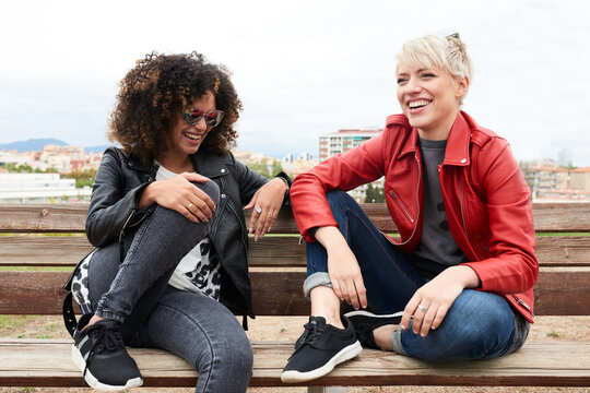 Young girls sitting on a bench smiling and having fun