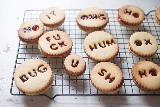 Shortbread biscuits / cookies filled with jam and buttercream spelling swear words