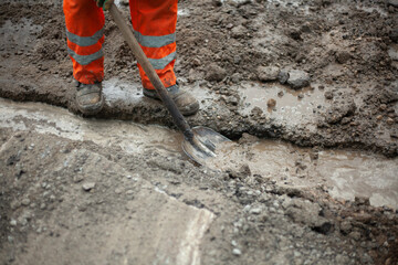 Workers remove water from the trench. 