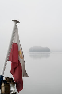 Polish flag on a boat at lake on a foggy morning