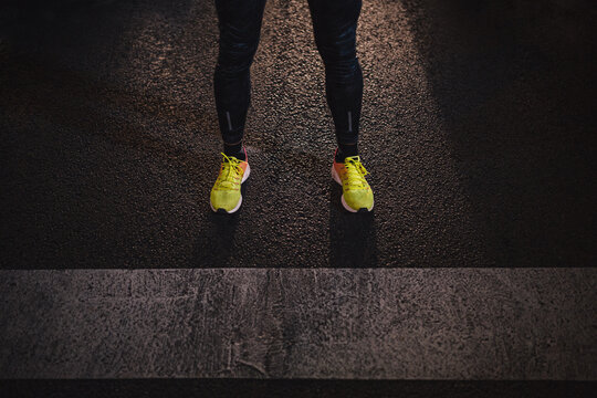 Closeup of runner shoes standing on the road at night