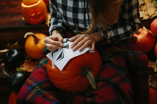 Woman pierce the pumpkin pattern for Haloween
