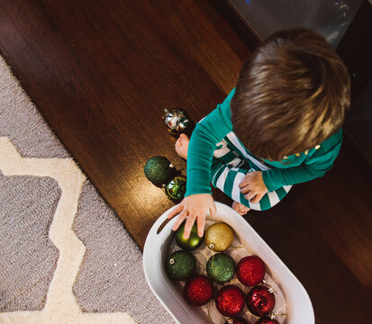 a little boy helps decorate with (unbreakable) ornaments