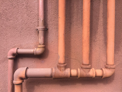 Close up of brown utility pipes on building wall
